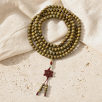 Mala Tibétain 108 Perles Bois de Verawood 10 mm — photographie produit sur travertin beige