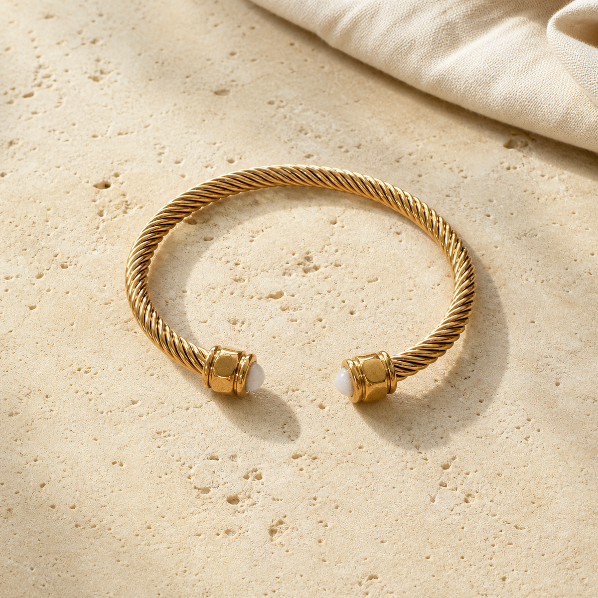 Bracelet Jonc Torsadé Doré en Pierre Naturelle — photographie produit sur travertin beige