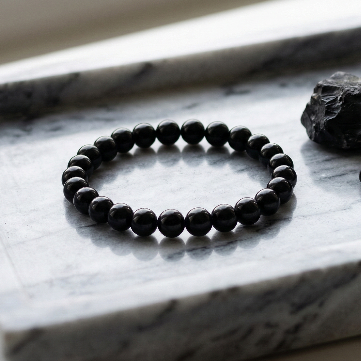 Bracelet onyx noir perles polies gros plan protection