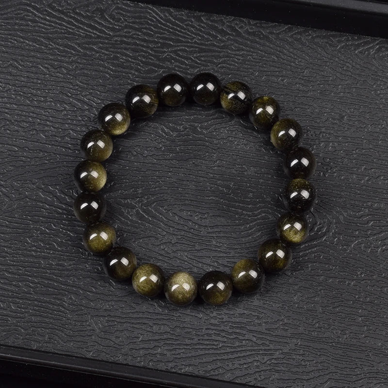 Bracelet obsidienne dorée 8 mm à plat sur ardoise noire